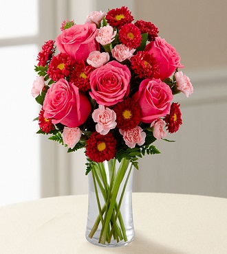 Assorted pink and red flowers in a clear glass vase