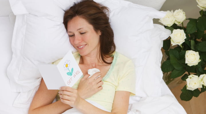 Woman reading gift card in bed